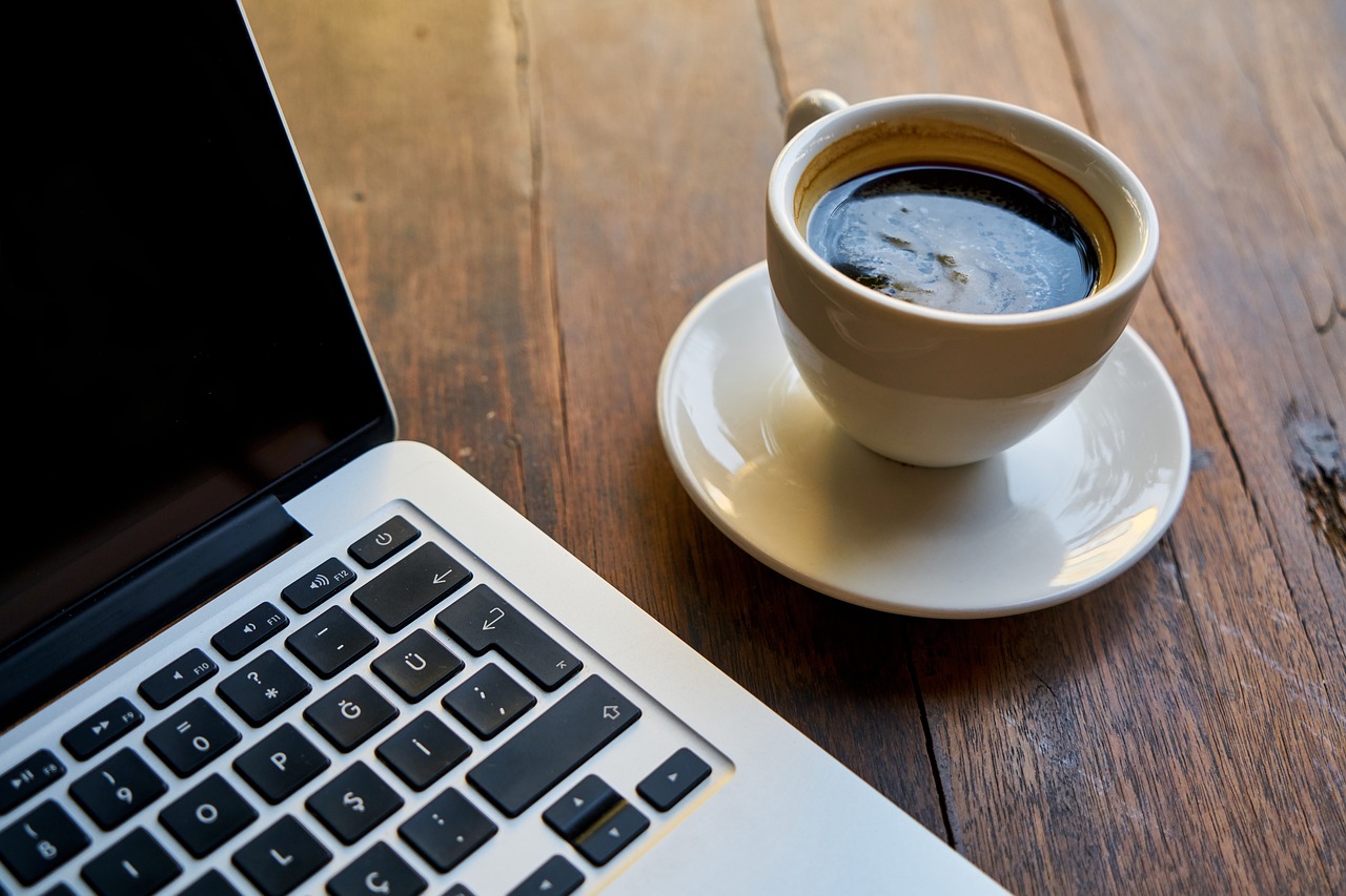 Laptop-Tastatur mit einer Tasse Kaffee
